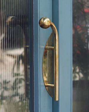 Site Practice - Brass door handle and other bespoke details contrast with the cool tones of blue. Photo: Americano